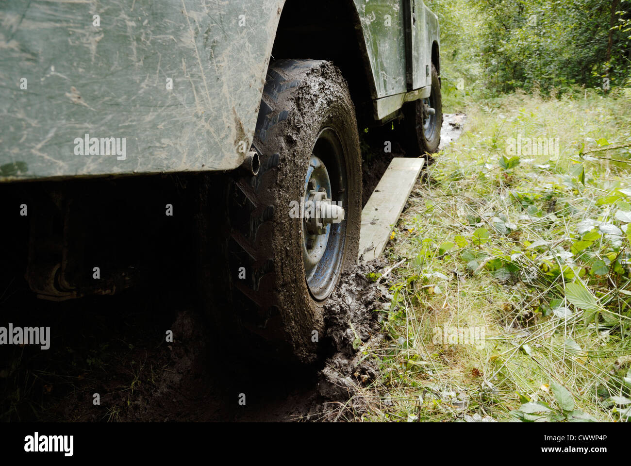 Assi di legno che viene utilizzato per fornire la trazione a un landrover bloccato nel fango, Galles. Foto Stock