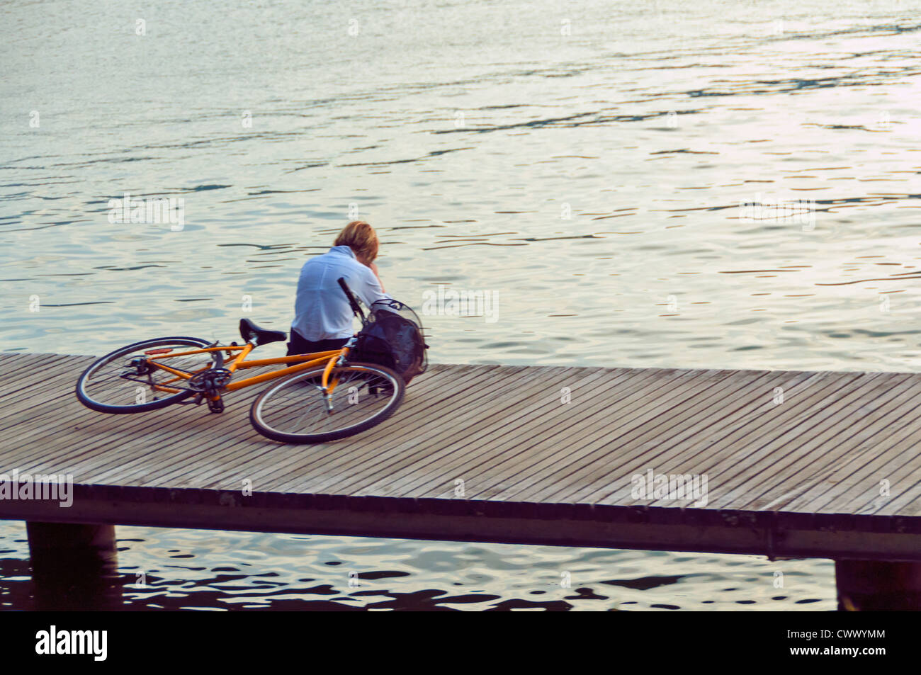 Ciclista appoggiato accanto al lago di Annecy Foto Stock