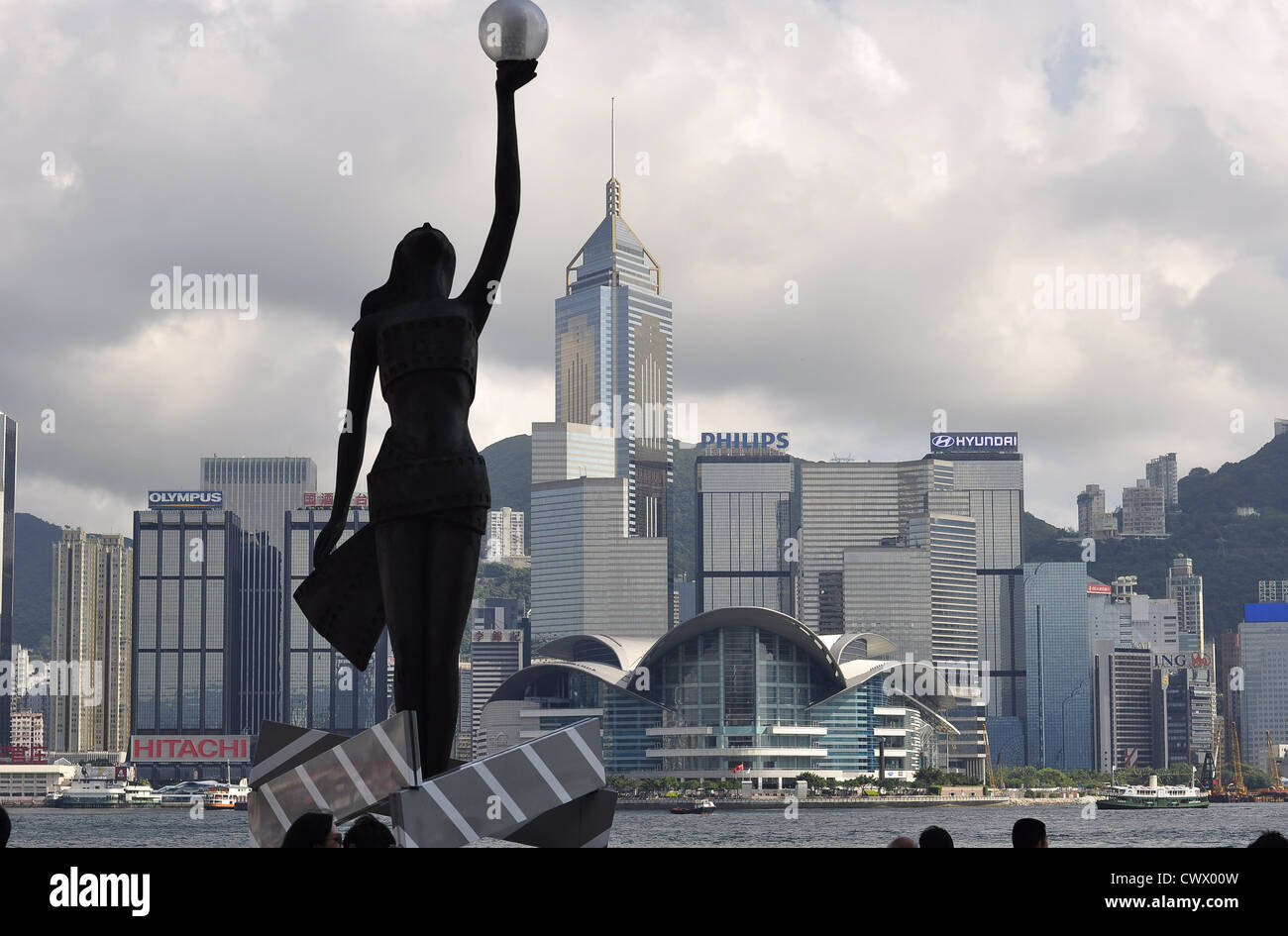 "Hong Kong Film Awards' statua (donna tenendo una palla) con lo skyline di Hong Kong in background (Hong Kong (Cina) Foto Stock