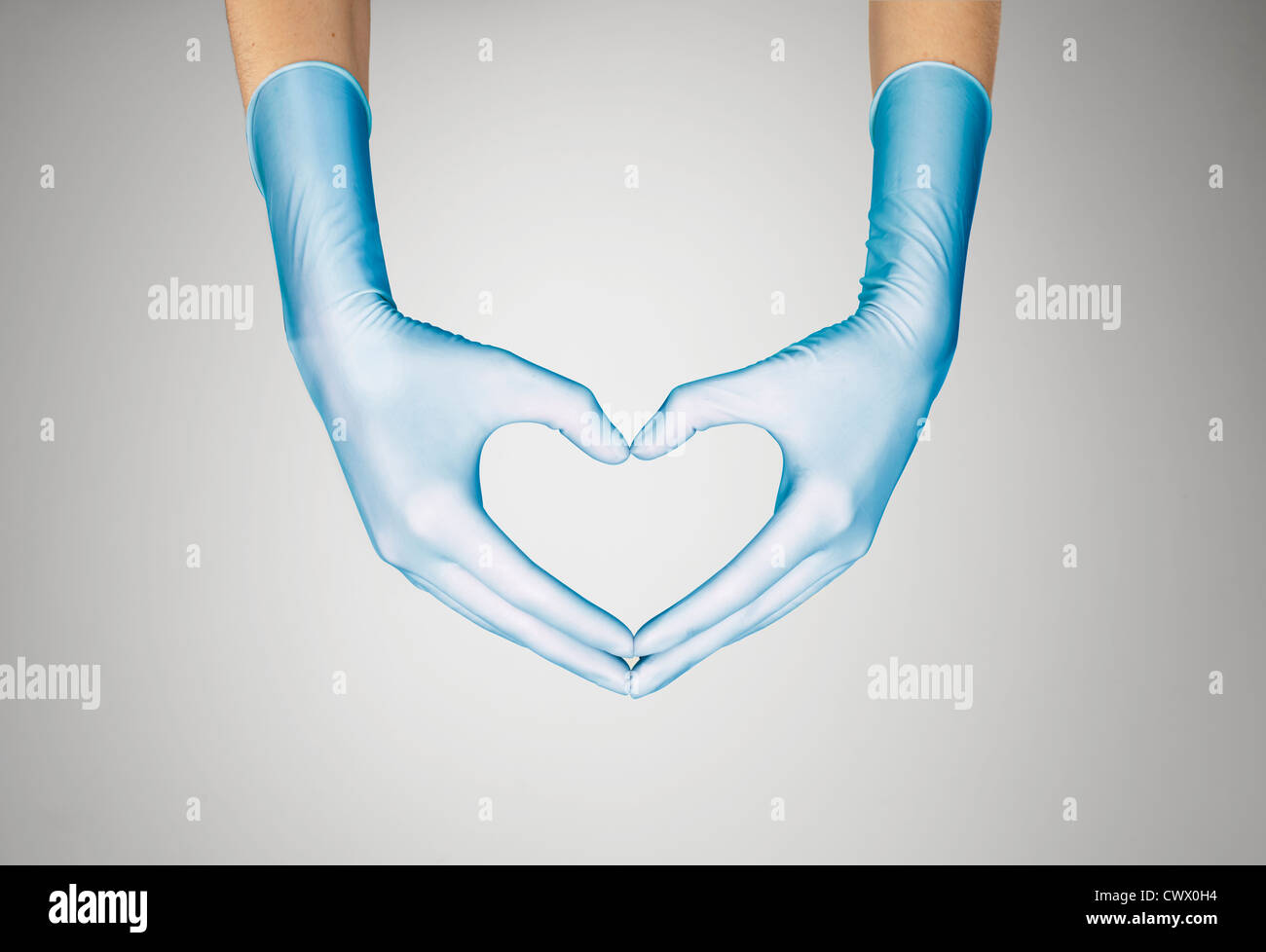 Mani guantate messa a forma di cuore Foto Stock