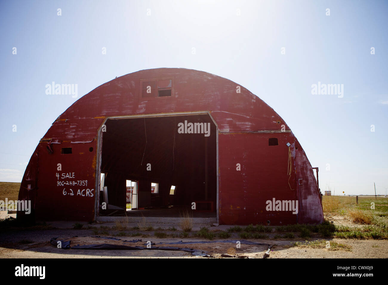 Abbandonato retroilluminato Quonset hut lungo il percorso 66 in Texas, precedentemente noto come un negozio di alimentari o stazione di gas Foto Stock