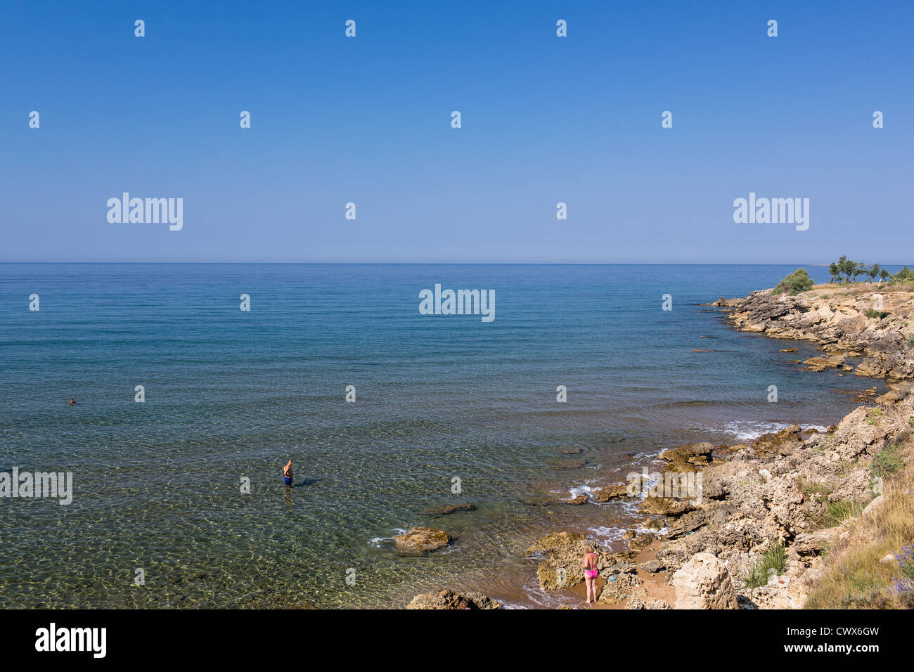 I turisti su una costa selvaggia in Agios Georgios, Corfu, Isole Ionie, Grecia. Foto Stock