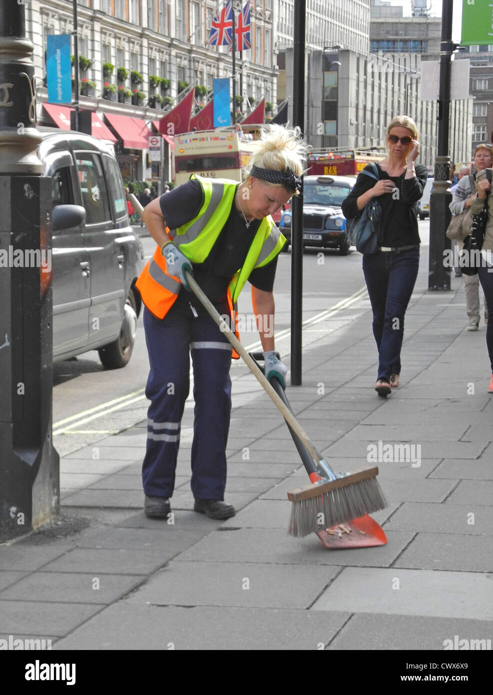 A Londra donna femmina lady street cleaner lavorando su Buckingham Palace Road solo uso editoriale Foto Stock