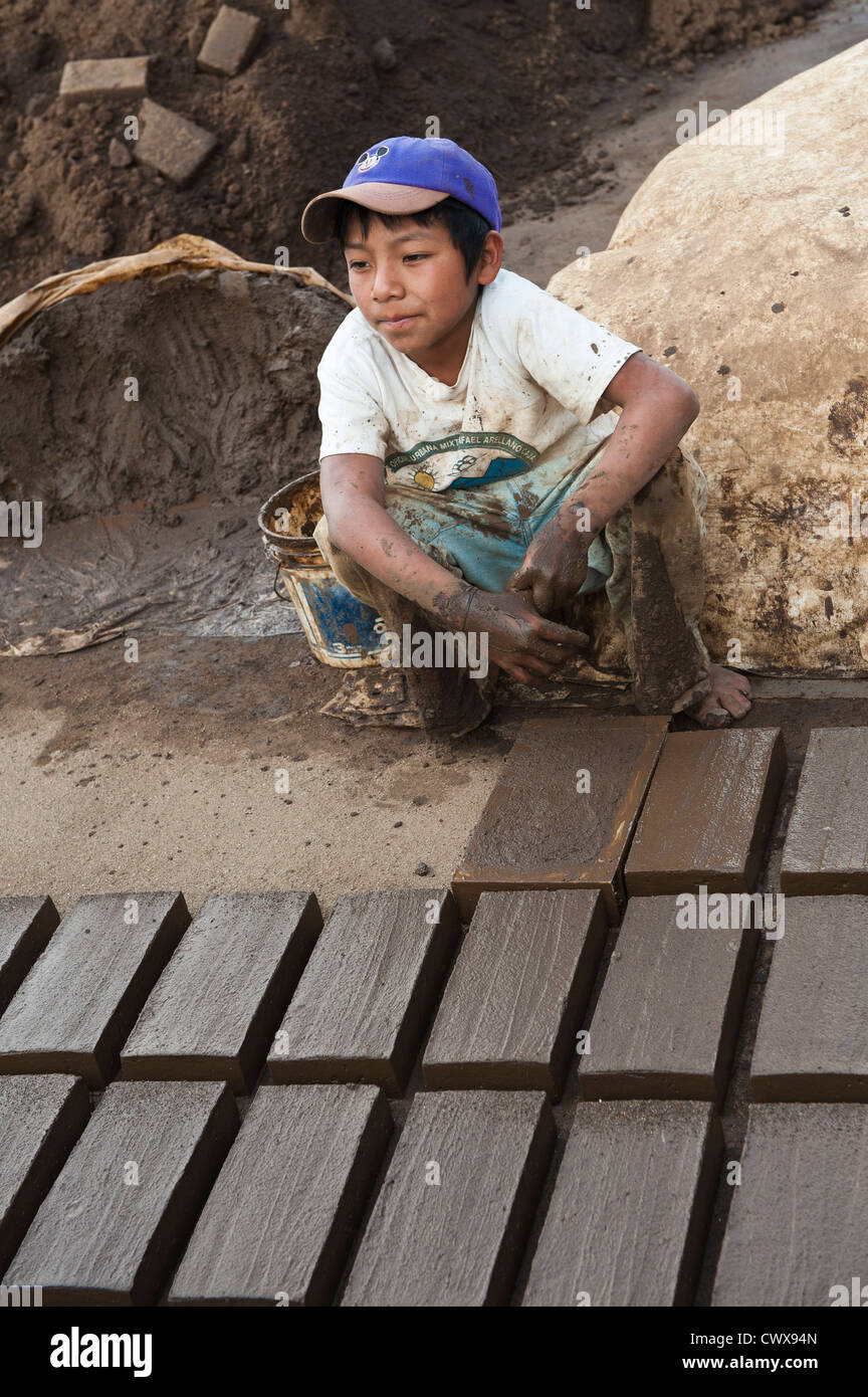 Maya Maya boy rendendo tegole e mattoni di argilla in fabbrica al di fuori di Antigua, Guatemala, Sito Patrimonio Mondiale dell'UNESCO. Foto Stock