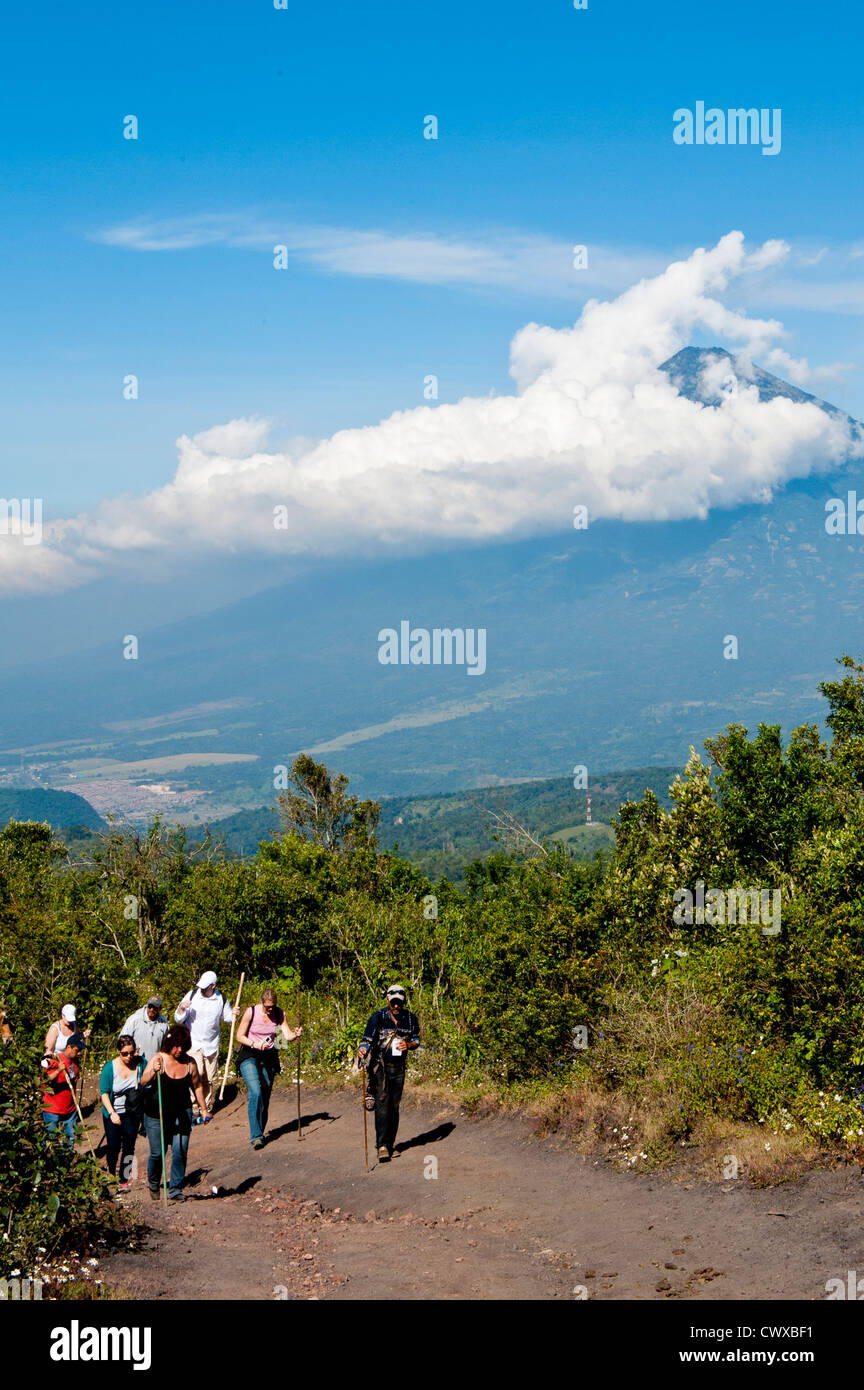 Gli escursionisti sul vulcano Pacaya, con Fuego vulcano a distanza Antigua, Guatemala, America centrale. Foto Stock