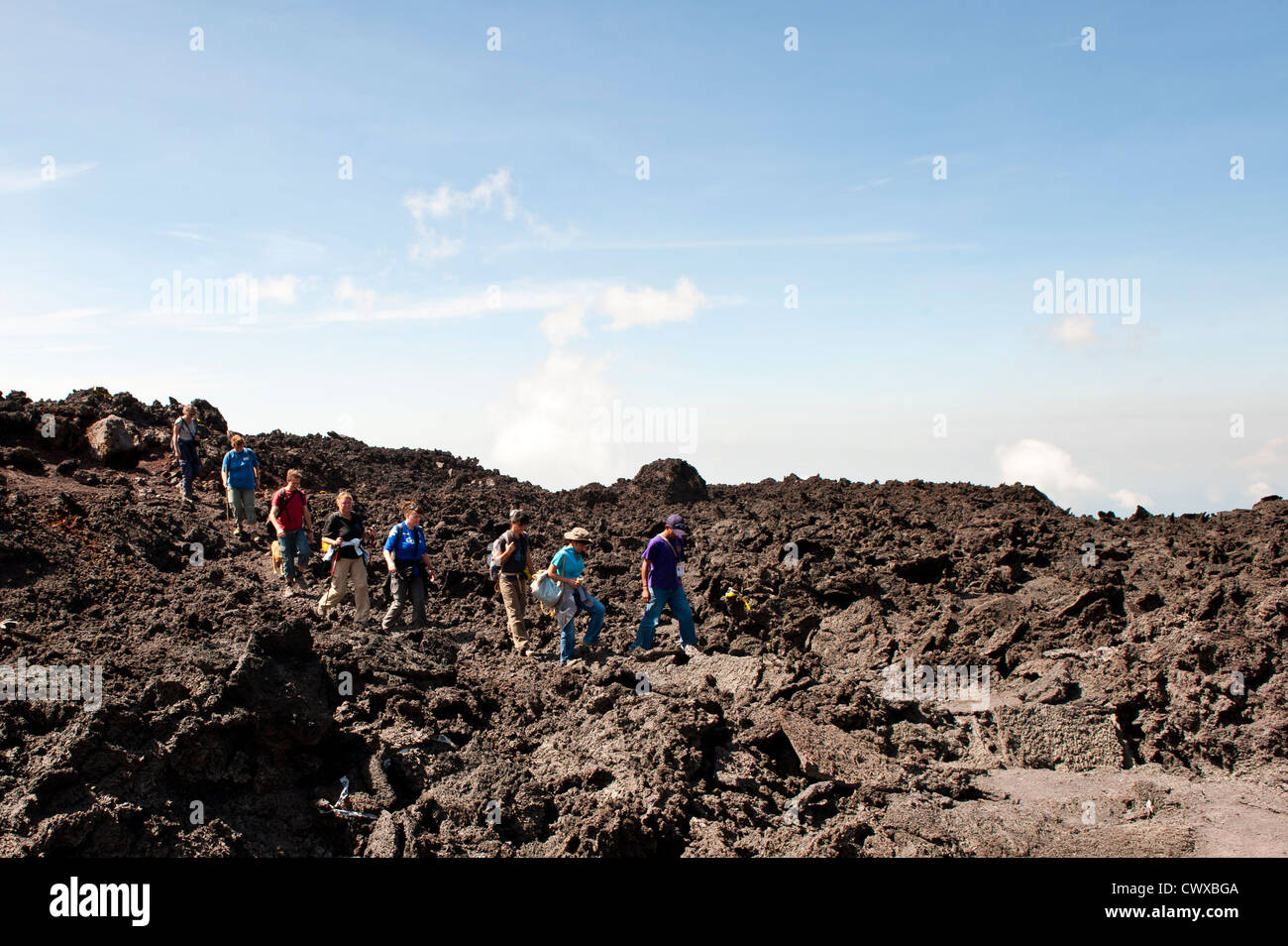 Gli escursionisti sul vulcano Pacaya, con Fuego vulcano a distanza Antigua, Guatemala, America centrale. Foto Stock