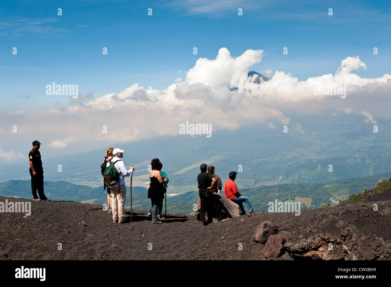 Gli escursionisti sul vulcano Pacaya, con Fuego vulcano a distanza Antigua, Guatemala, America centrale. Foto Stock