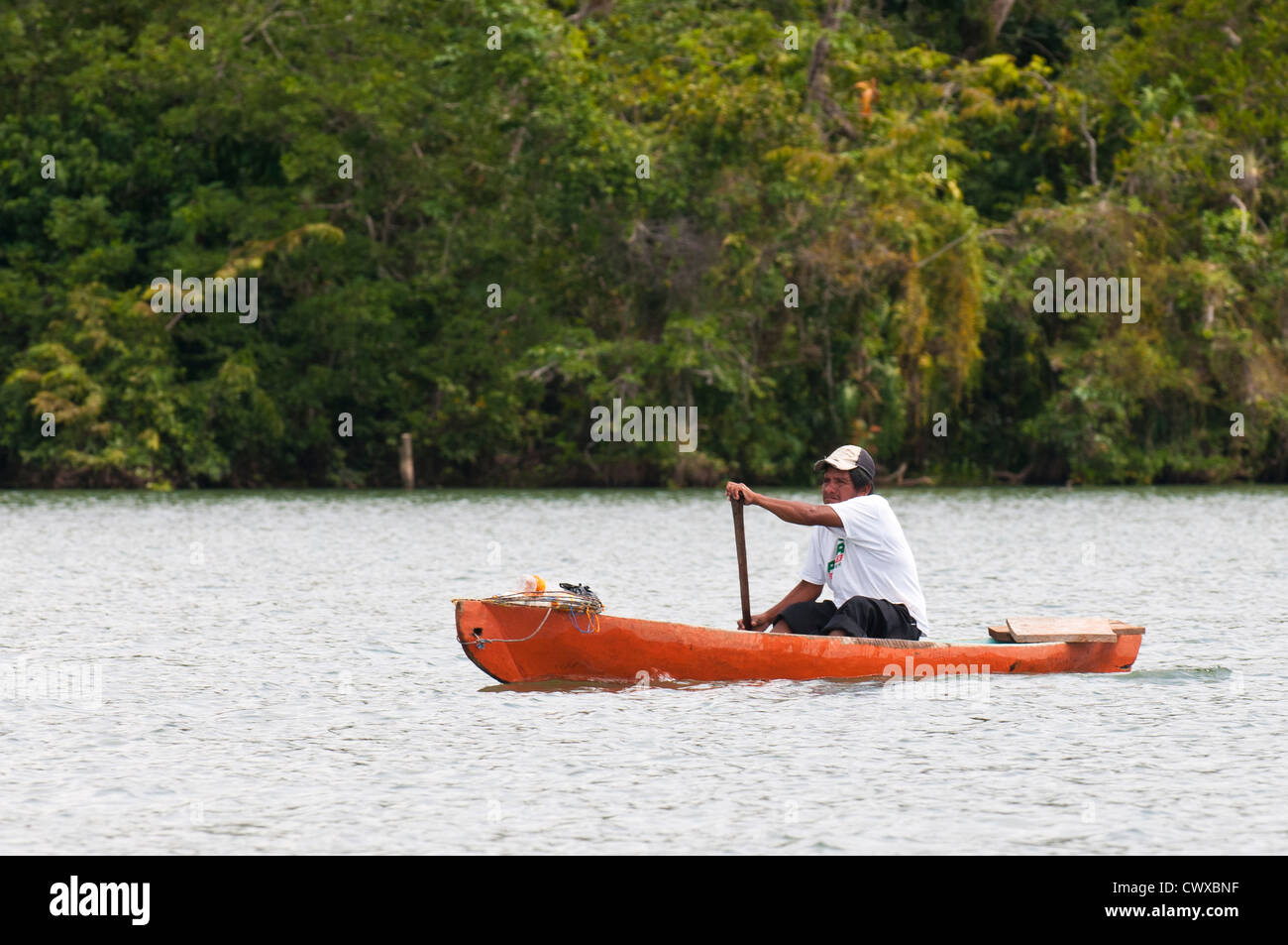 Garifuna fisherman paddling piroga barca sul lago Izabal, Lago de Izabal, Guatemala. Foto Stock