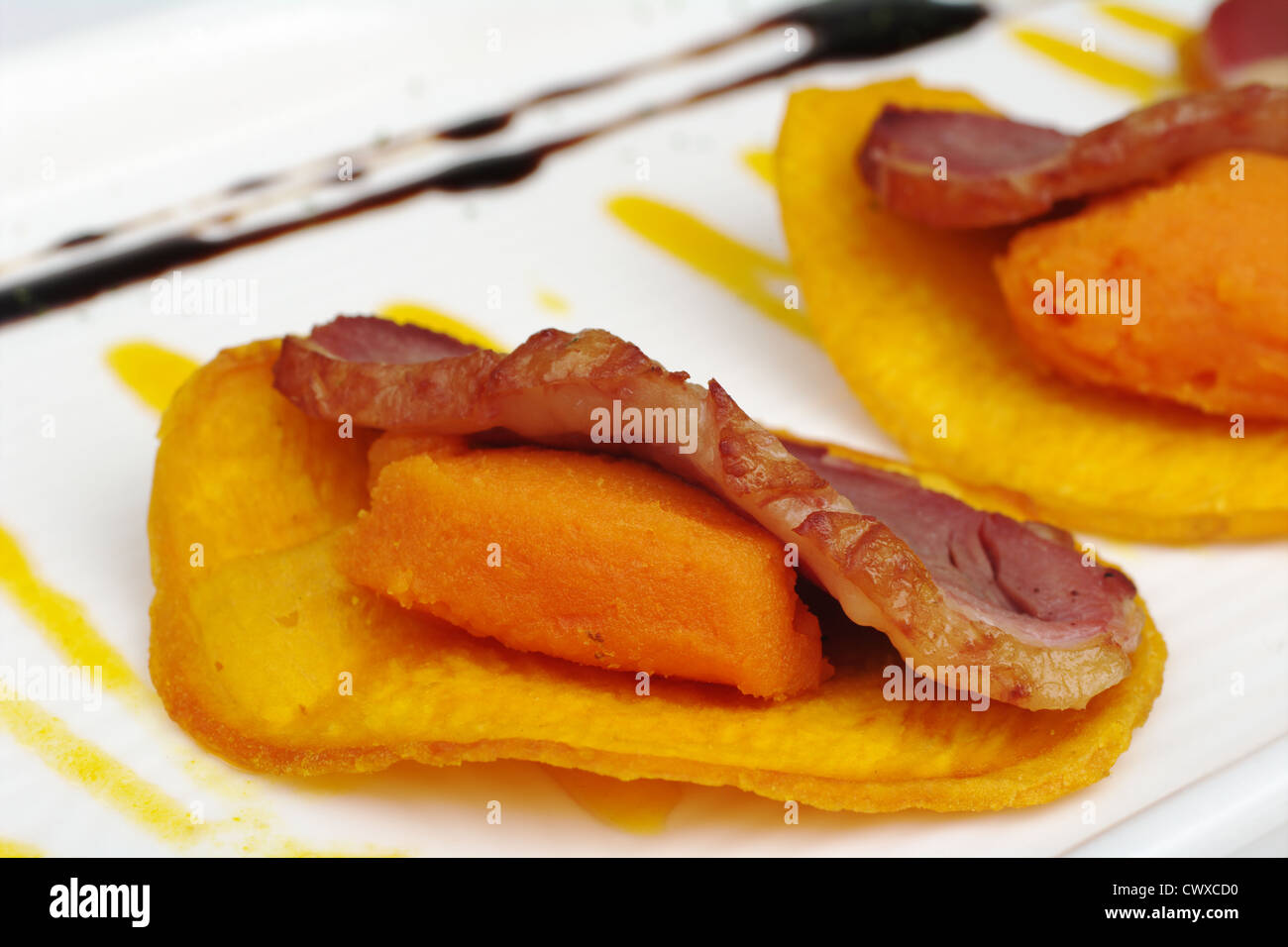 Antipasto: carne di anatra con patate dolci sulla purea di patate dolci chip (messa a fuoco selettiva) Foto Stock