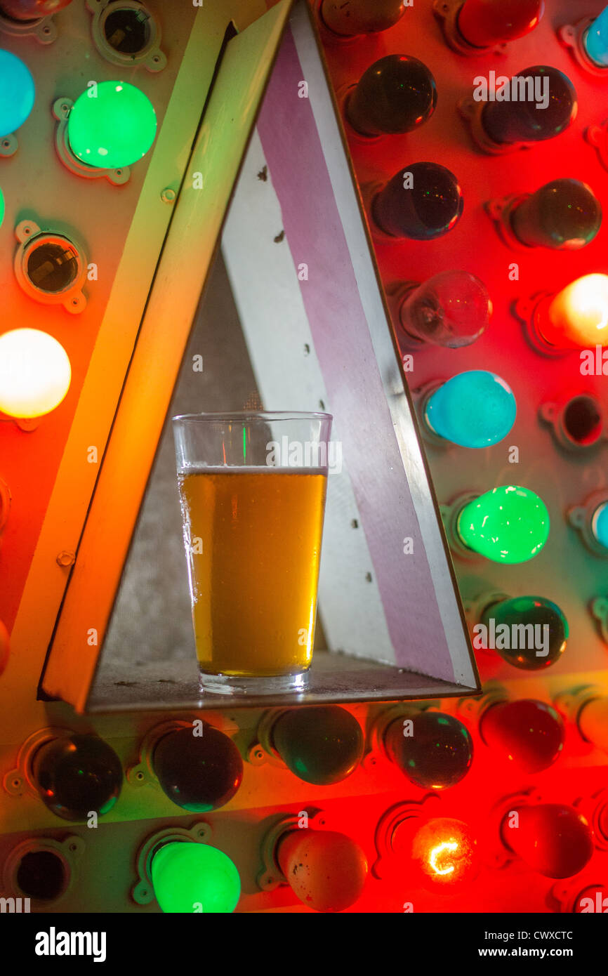 Una pinta di birra illuminato da luci colorate Foto Stock