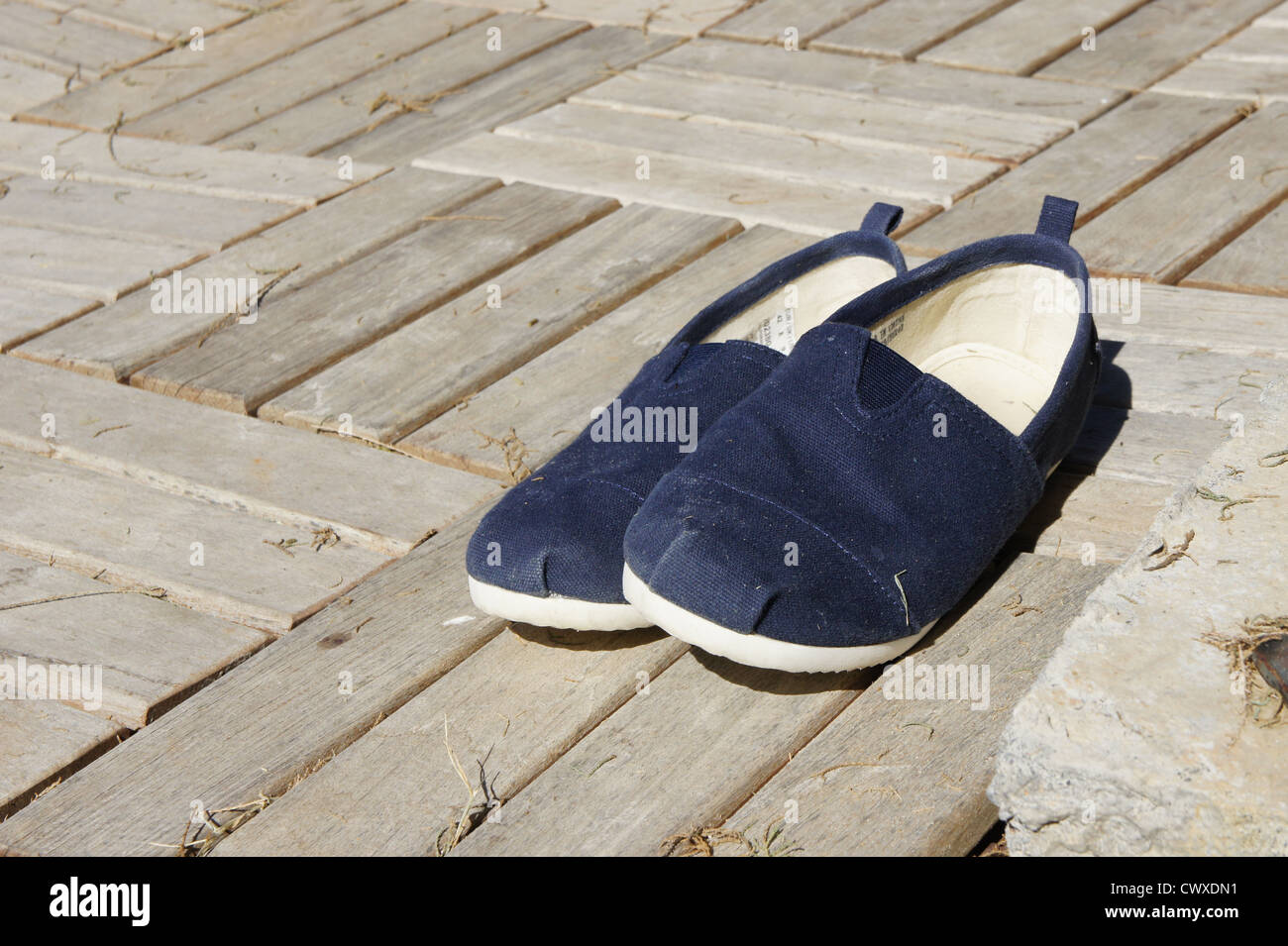 Indossare le scarpe da spiaggia su sun imbianchiti decking Foto Stock