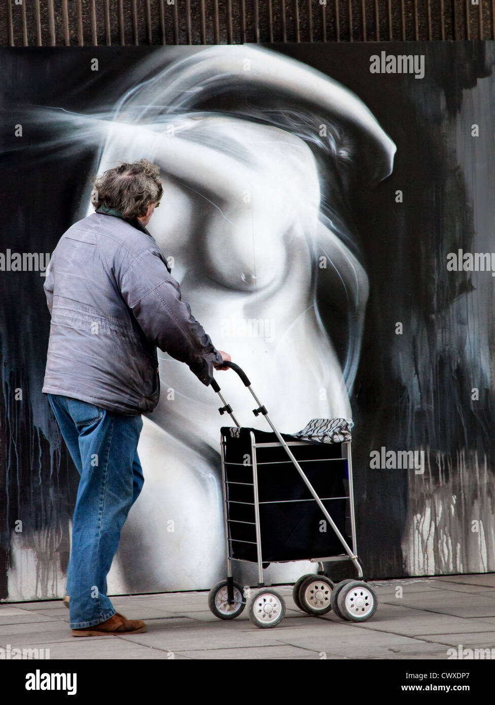 La gente camminare passato graffiti Foto Stock