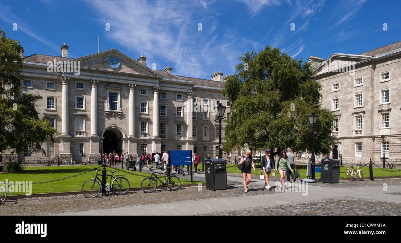 Gli studenti universitari camminando sul campus presso il Trinity College di Dublino, Irlanda davanti alla scuola di diritto edificio in estate Foto Stock