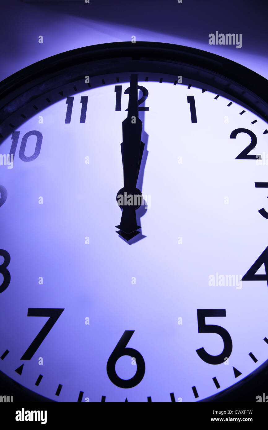 Un orologio con mani rivolta verso la metà della notte. Foto Stock