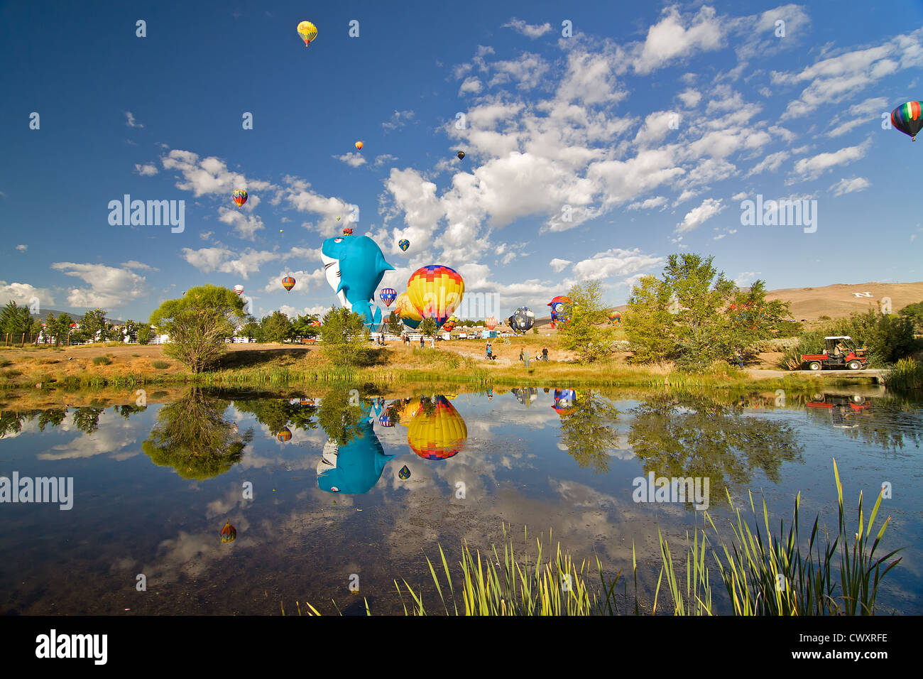 Palloncini ad aria calda che si riflettono su un grande stagno a Reno, Nevada. La caramella dell'occhio è l'unico senso descrivere i palloncini dell'aria calda. Foto Stock