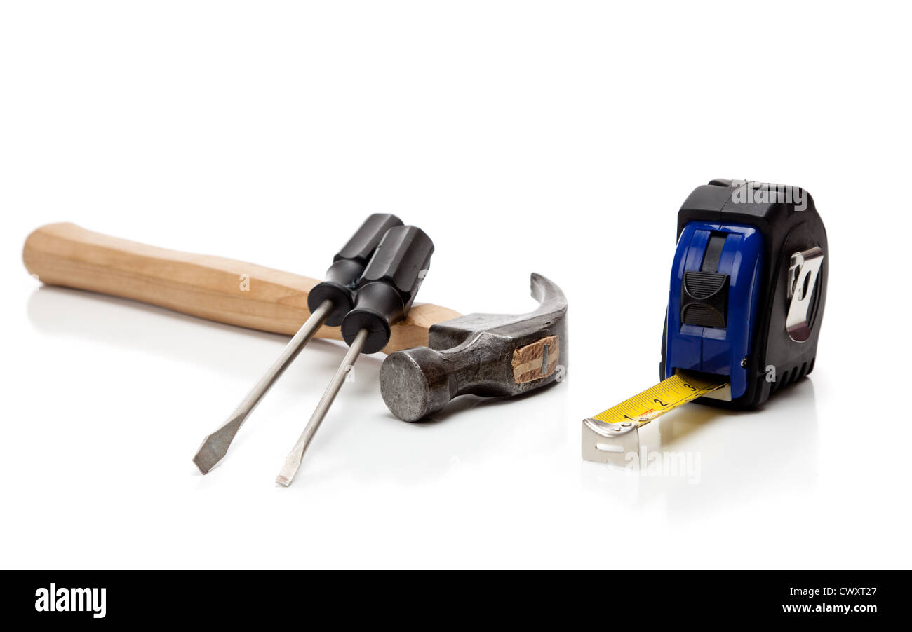 Un assortimento di strumenti tra cui martello, avvitatori e una misura di nastro su sfondo bianco Foto Stock