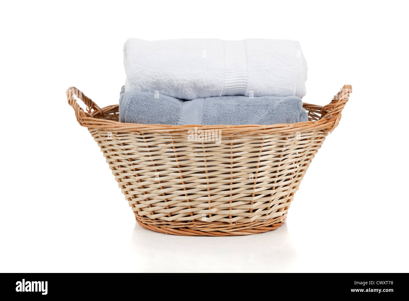 In vimini una cesta per biancheria con il bianco e il grigio asciugamani su sfondo bianco Foto Stock