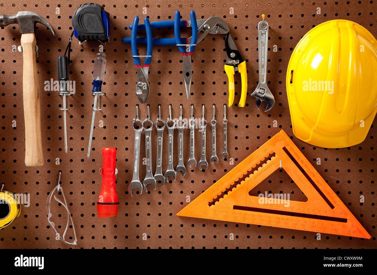 Un tabellone con vari strumenti quali: martello, chiavi, torcia, cacciaviti Foto Stock