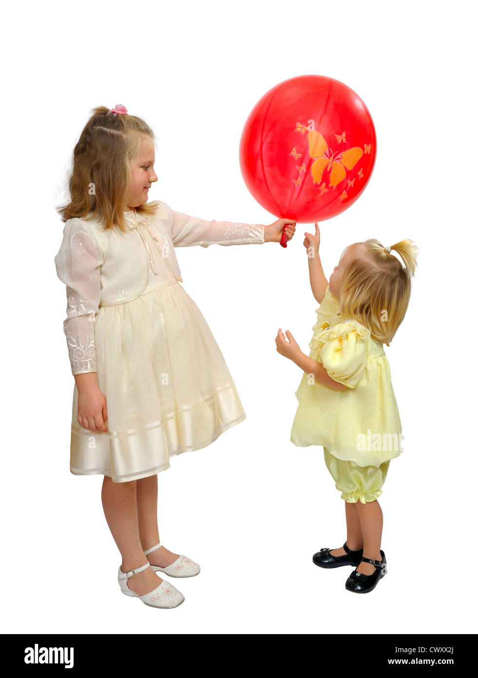 Ragazze in abiti a fantasia giocare con un palloncino rosso. Foto Stock