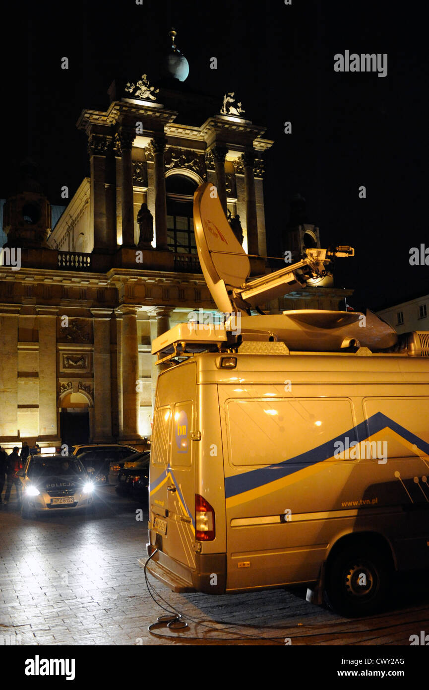 Un furgone di un'azienda televisiva assistita da un auto della polizia durante una trasmissione in diretta di fronte ad una chiesa. Foto Stock