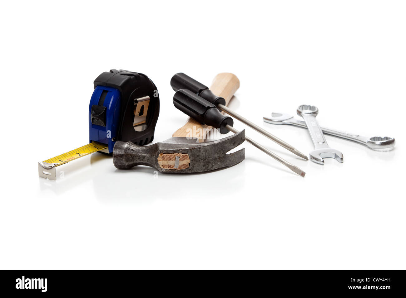 Un assortimento di strumenti tra cui un martello, un nastro di misurazione cacciaviti e chiavi su sfondo bianco Foto Stock