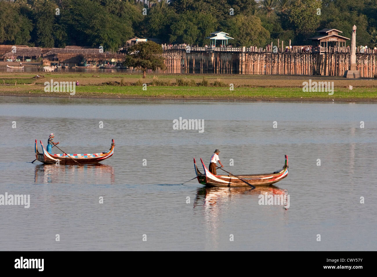 Myanmar Birmania, Mandalay. Lago Taungthaman. Due barche nel sole del pomeriggio, U Bein Bridge in background. Foto Stock
