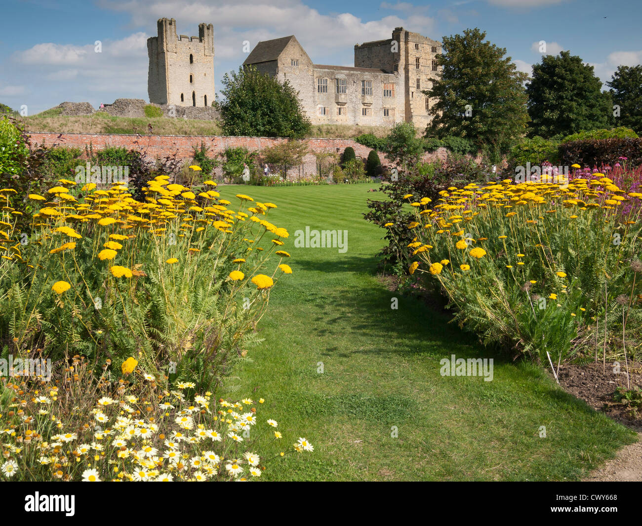 Helmsley castello affacciato sul Helmsley Walled Garden con uno spettacolo di fiori d'estate Foto Stock