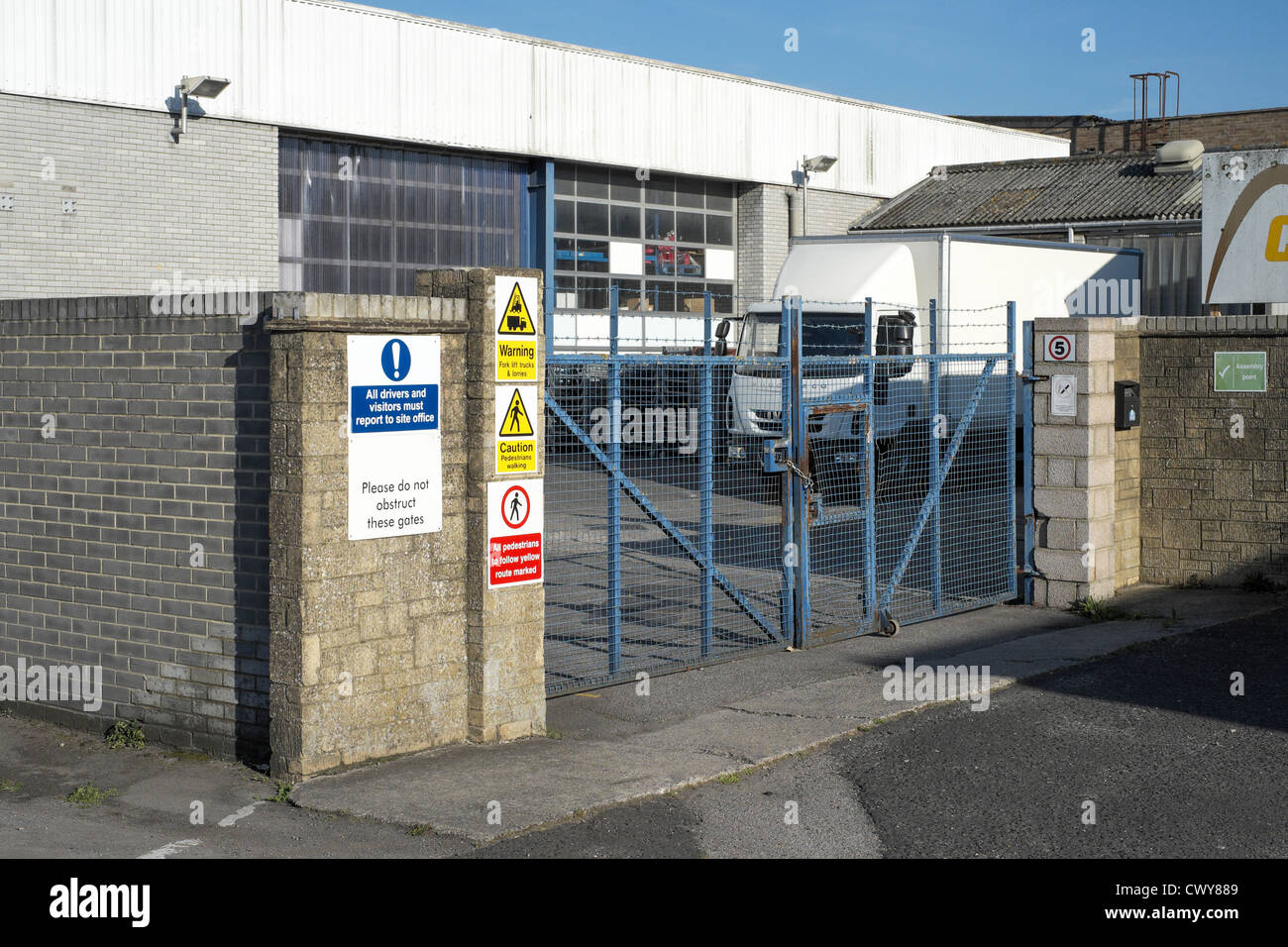Ingresso al composto industriale con camion, bloccato i cancelli di sicurezza e cartelli di avvertimento Foto Stock