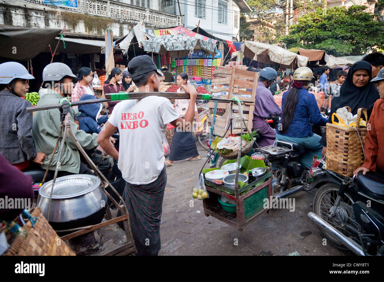 Myanmar Birmania. Mandalay Market Street il traffico. Cucina di strada venditore portando la sua Kit. Foto Stock