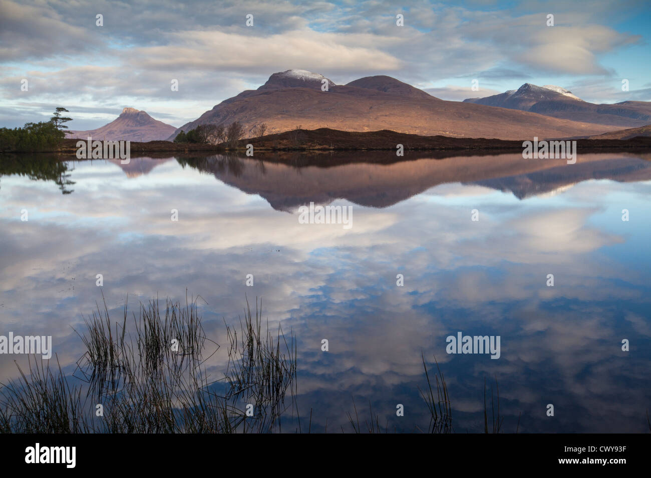 Riflessioni di montagna in Loch vicino a Ullapool Scozia Scotland Foto Stock
