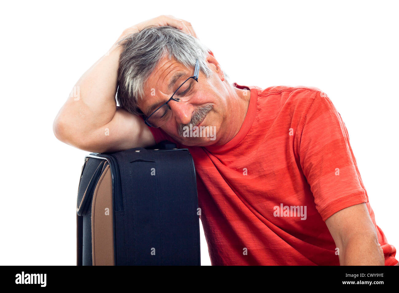 Stanco senior uomo dorme sul bagaglio, isolati su sfondo bianco. Foto Stock