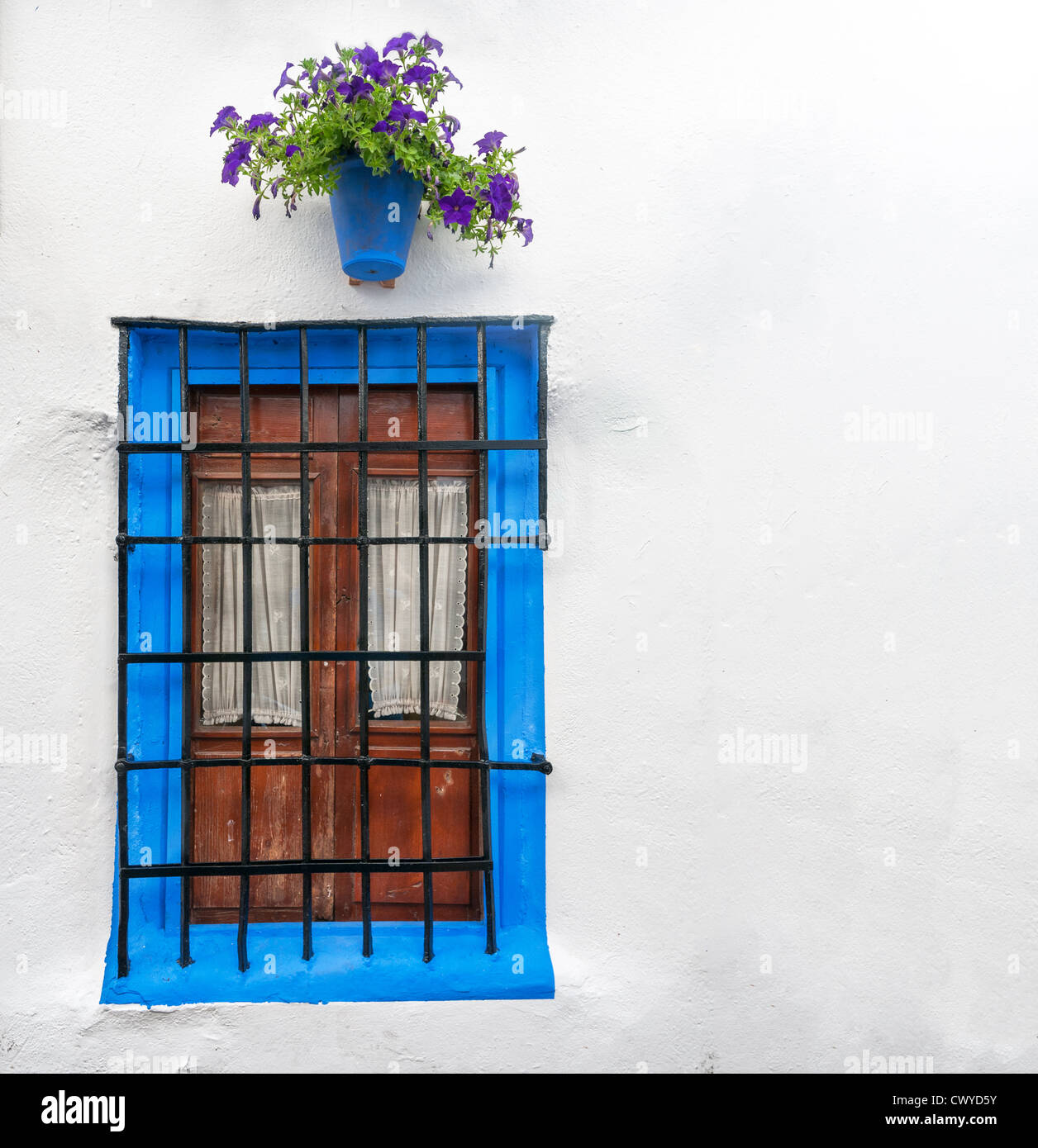 Parete di grandi dimensioni decorata in stile antico in Cordoba, Andalusia. Design rurale di casa in Spagna, Europa. Azzurro incorniciato in legno con finestra Foto Stock