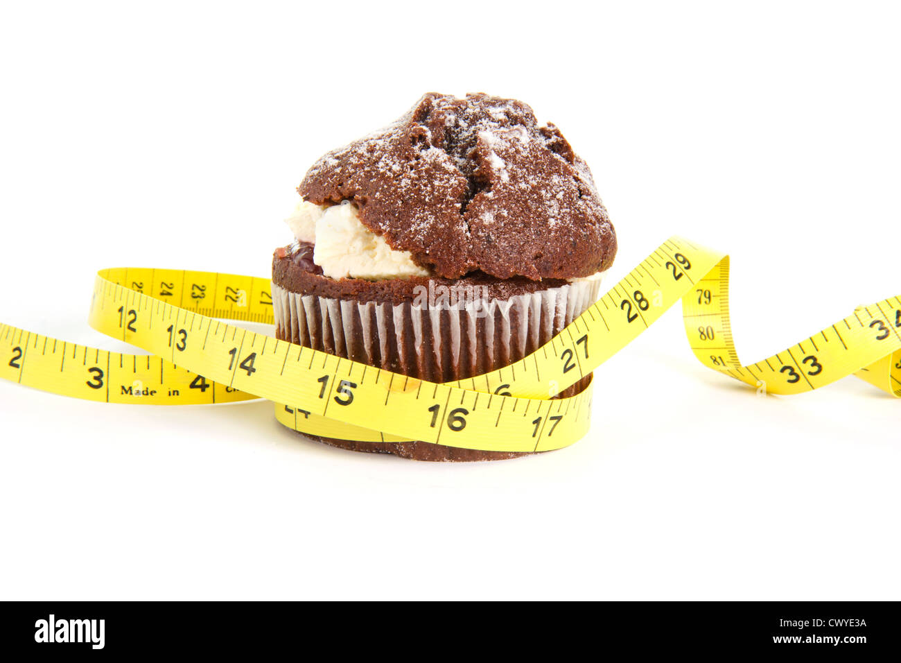 Muffin al cioccolato con una misura di nastro intorno ad esso su bianco Foto Stock