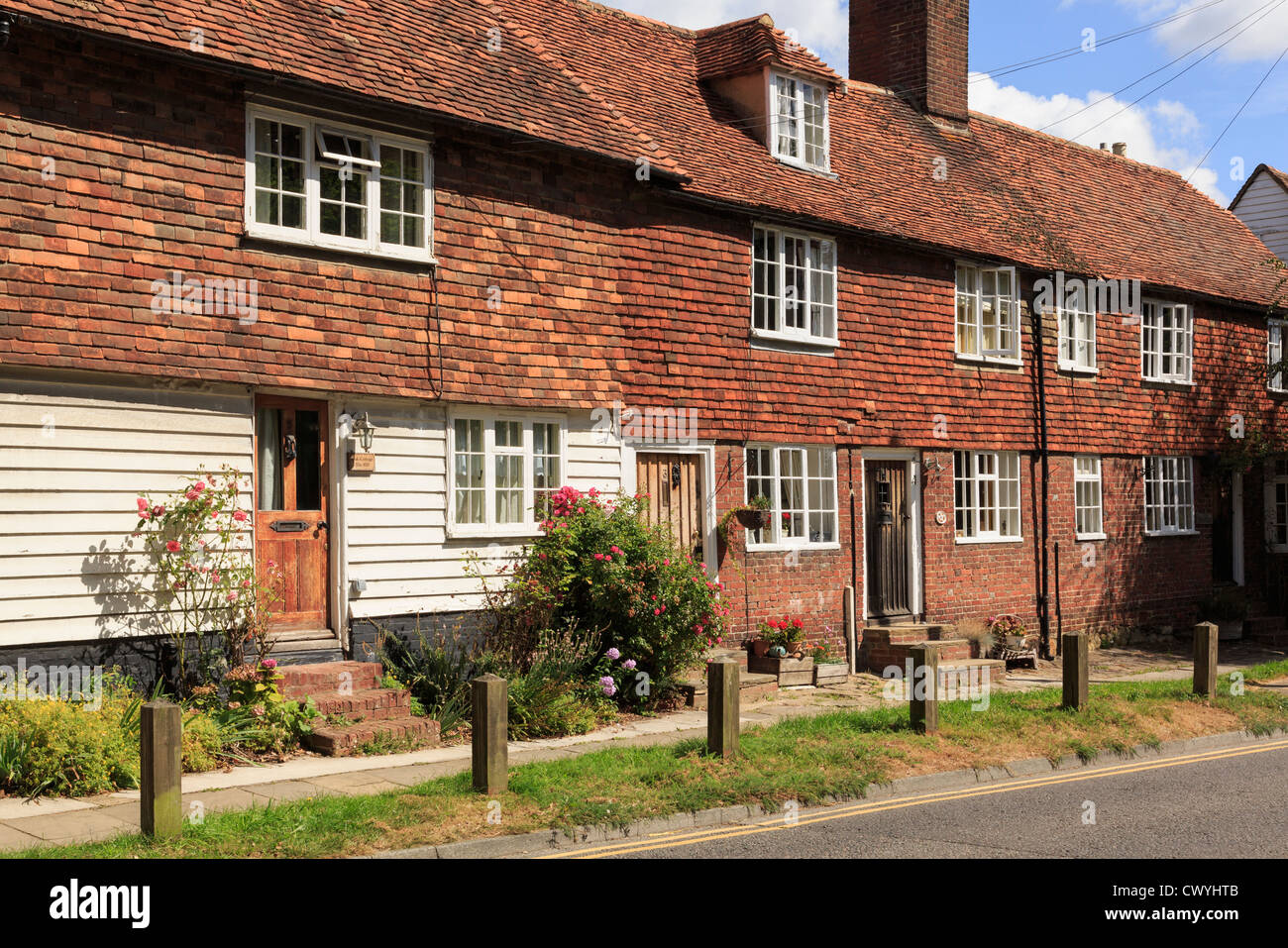 Fila di tipico vecchio Kentish piastrella appeso cottages con rose dalla porta in città Wealden di Cranbrook, Kent, Inghilterra, Regno Unito, Gran Bretagna Foto Stock