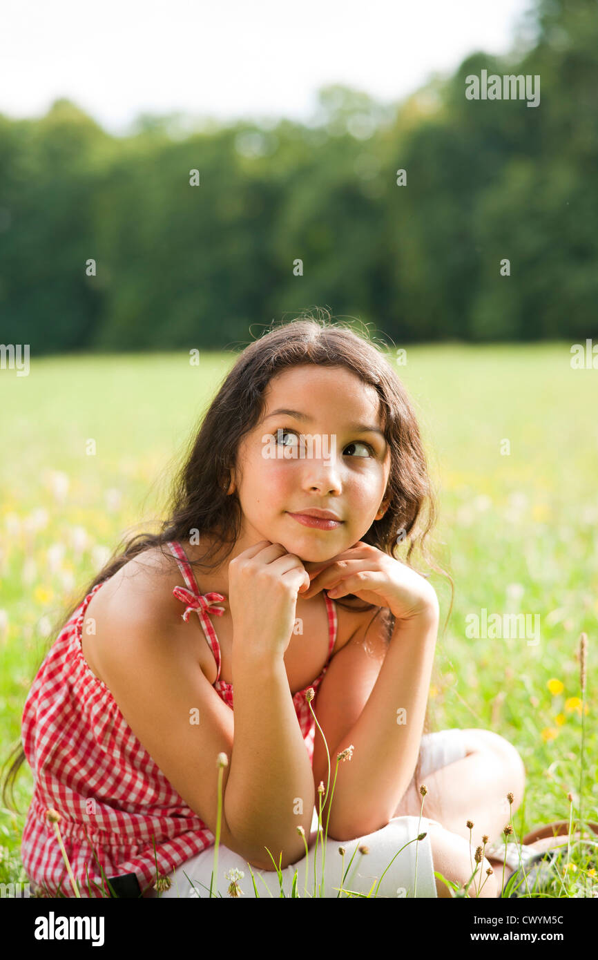 Ragazza seduta sul prato Foto Stock