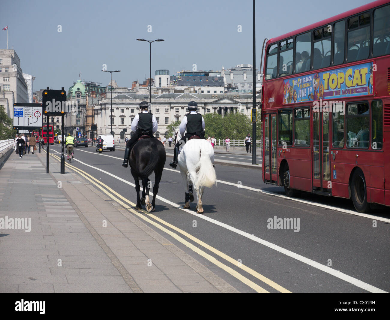 Due donne a cavallo di polizia piloti di pattuglia attraversando il ponte di Waterloo verso lo Strand, Londra Inghilterra Foto Stock