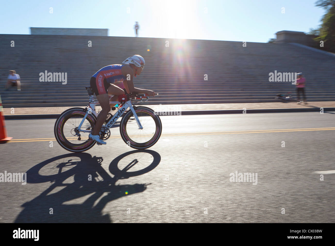 Ciclista racing in condizioni di intensa luce solare Foto Stock
