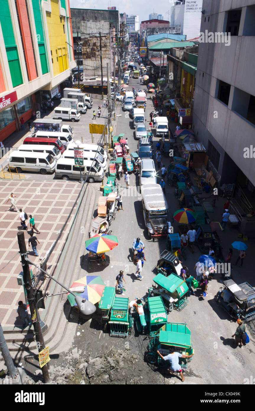 Una vista di una strada con molte automobili e negozi, Filippine. Foto Stock