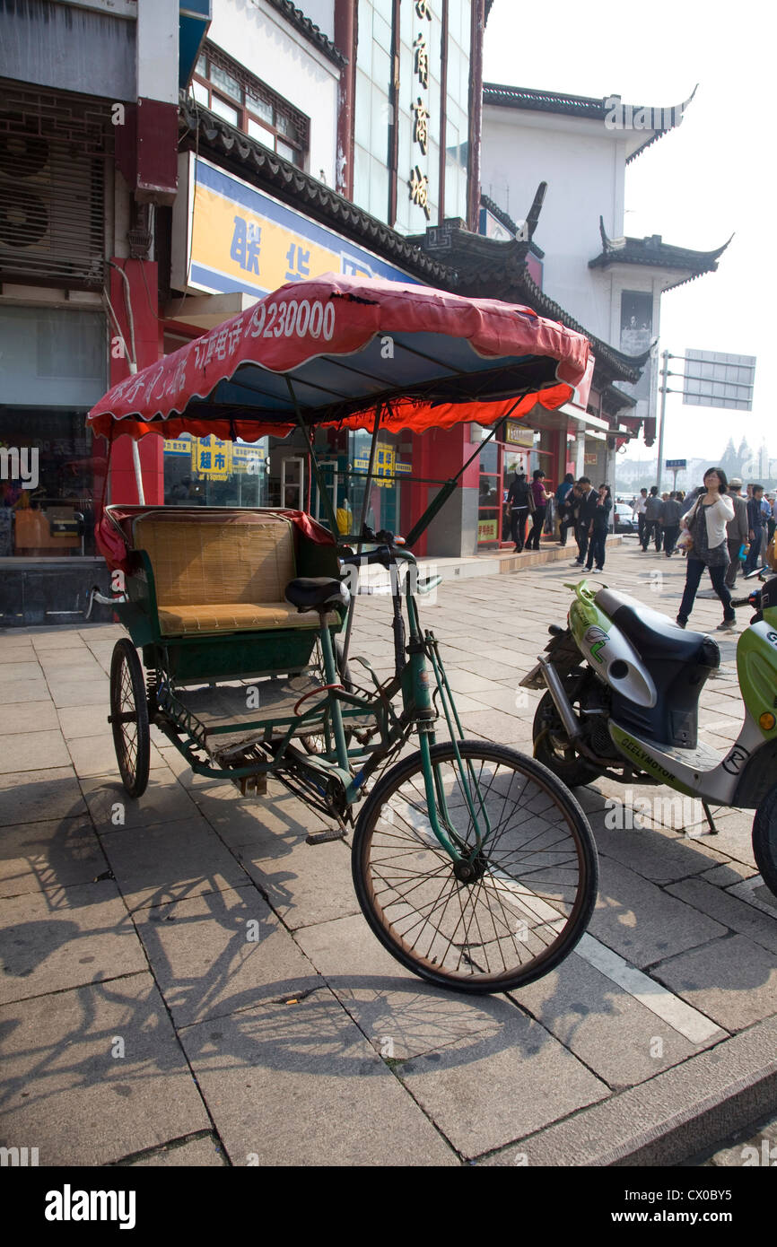 Risciò ciclo in una strada trafficata, Zhujiajiao, Cina Foto Stock