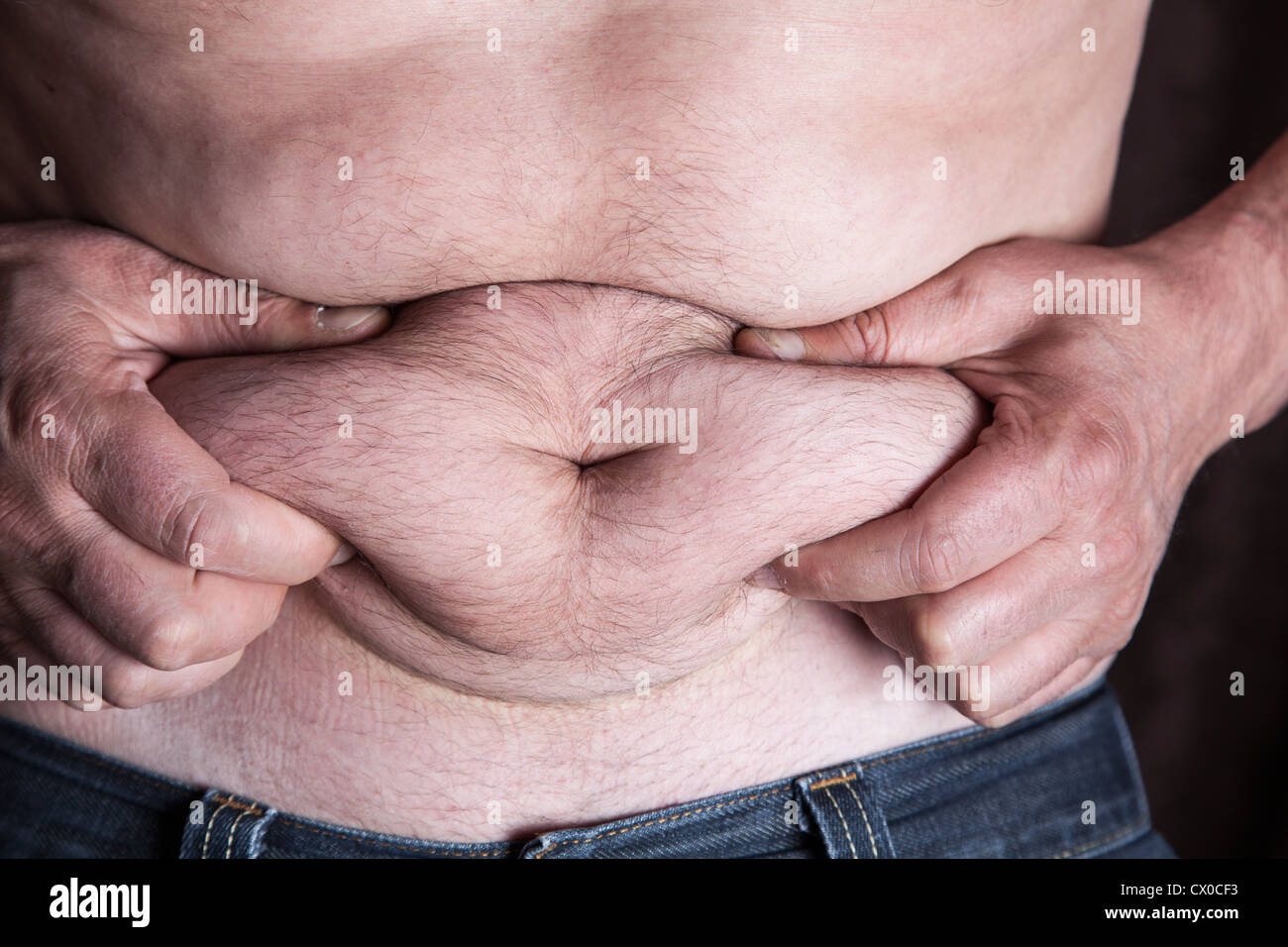 Uomo di mezza età mostra stomaco fat Foto Stock