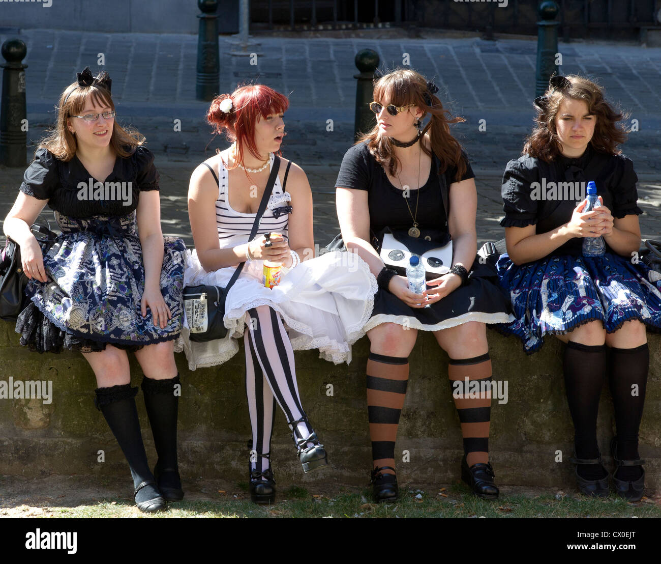 Quattro 4 ragazze seduta parlando di parete Foto Stock