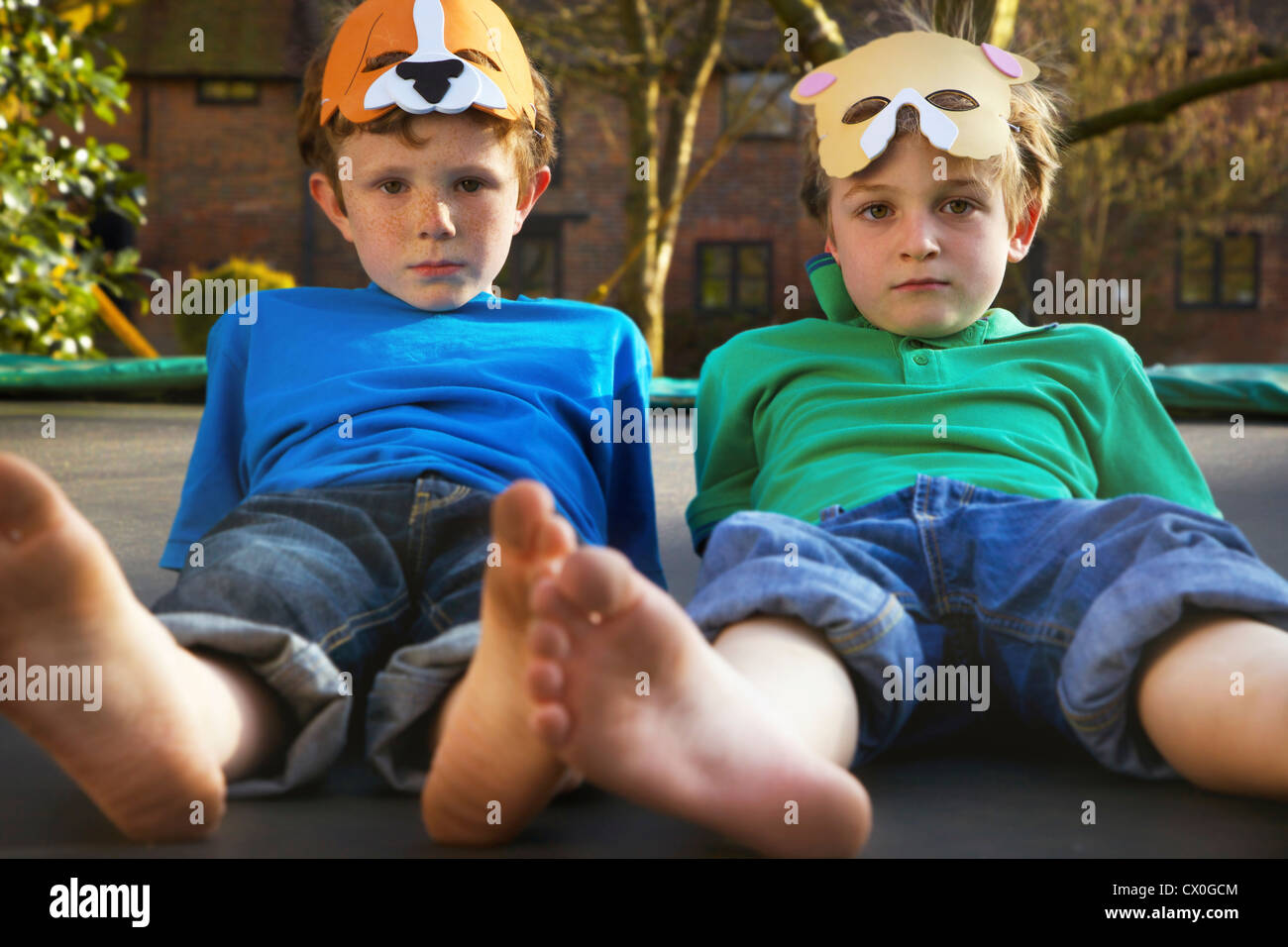 Due ragazzi indossare maschere giacente sul trampolino Foto Stock