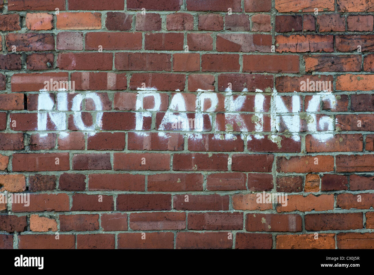 Parcheggio non dipinta su un muro di mattoni Foto Stock