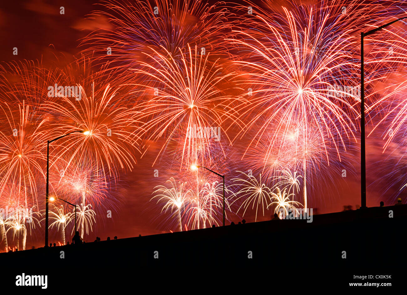 La gente guarda il quarto di luglio fuochi d'artificio da elevati cavalcavia. Foto Stock