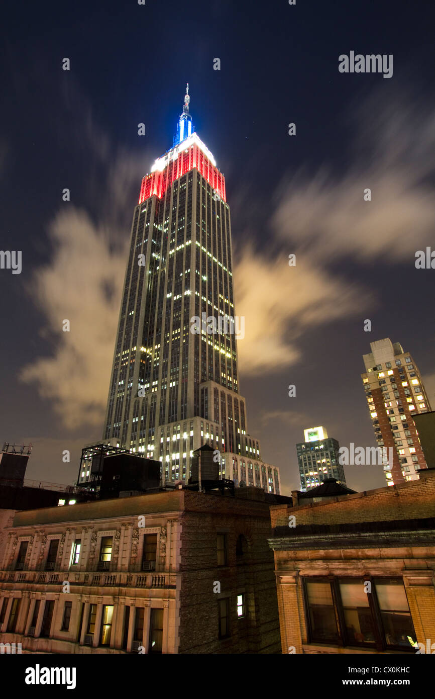 Empire State building di notte come si vede dall'Hotel Metro terrazza sul tetto. Accesa in rosso/bianco/blu per la giornata del lavoro 2012. Foto Stock