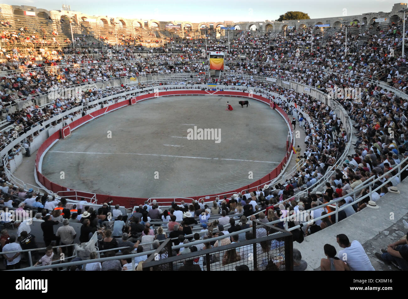 Arena romana o un anfiteatro Arles Francia con tutta la folla guarda la corrida corrida in tarda serata Foto Stock