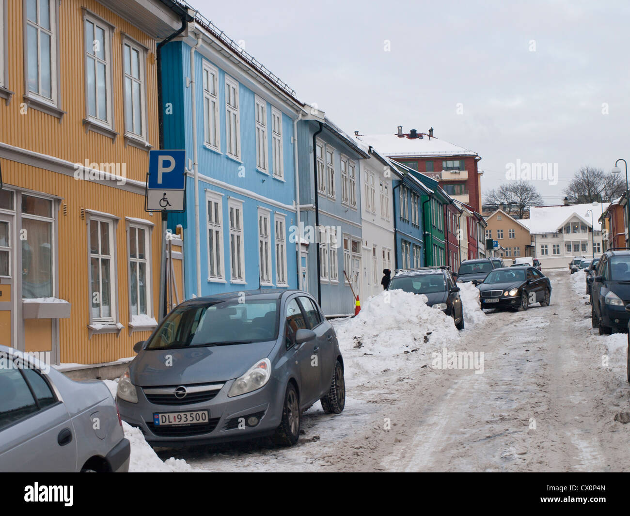 Inverno a Oslo Norvegia, una strada Vålerenga con vecchie case in legno, neve non liquidati di distanza e problemi di parcheggio per i residenti Foto Stock