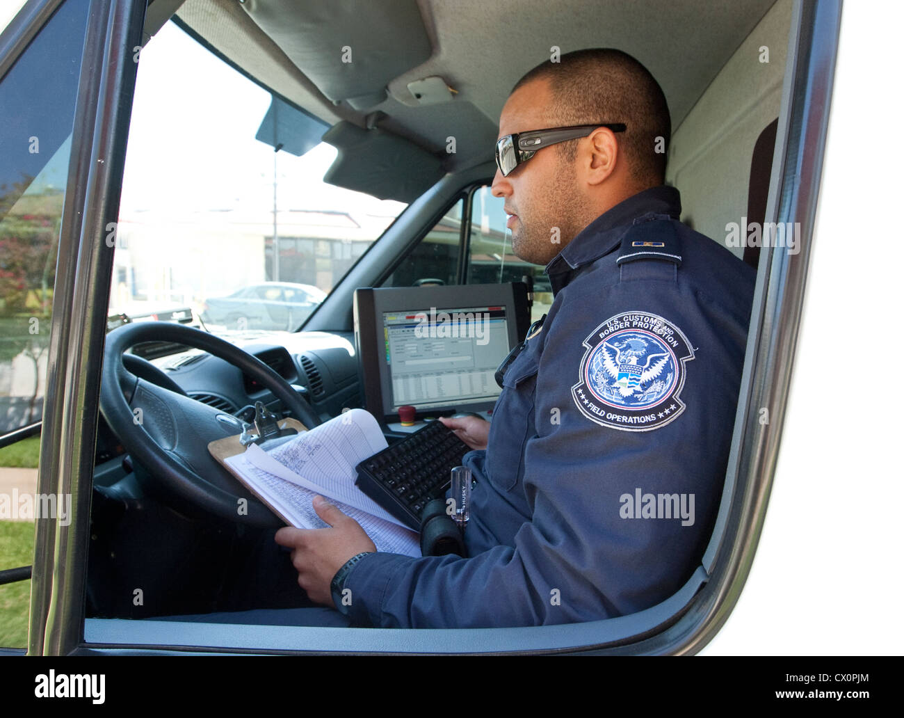 Officer aziona un mobile X-ray van scansioni diversi veicoli diretti verso il Messico per possibili armi nascoste a Laredo, Texas Foto Stock