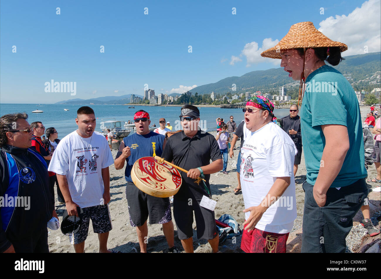 Squamish prima nazione tamburini e canoisti a Ambleside Beach, West Vancouver, BC, Canada Foto Stock