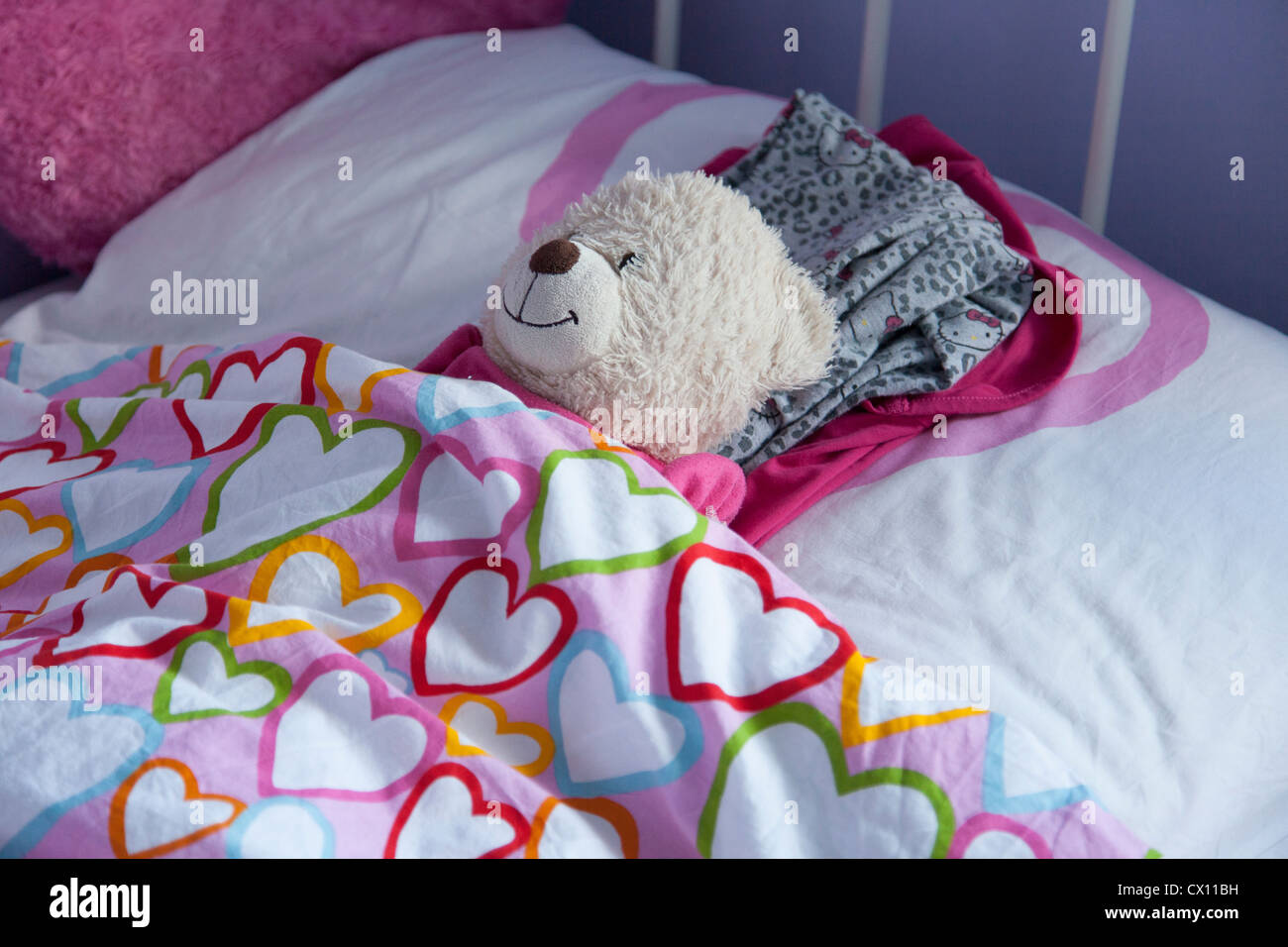 Teddy cari in nascosto nel letto da bambino Foto Stock